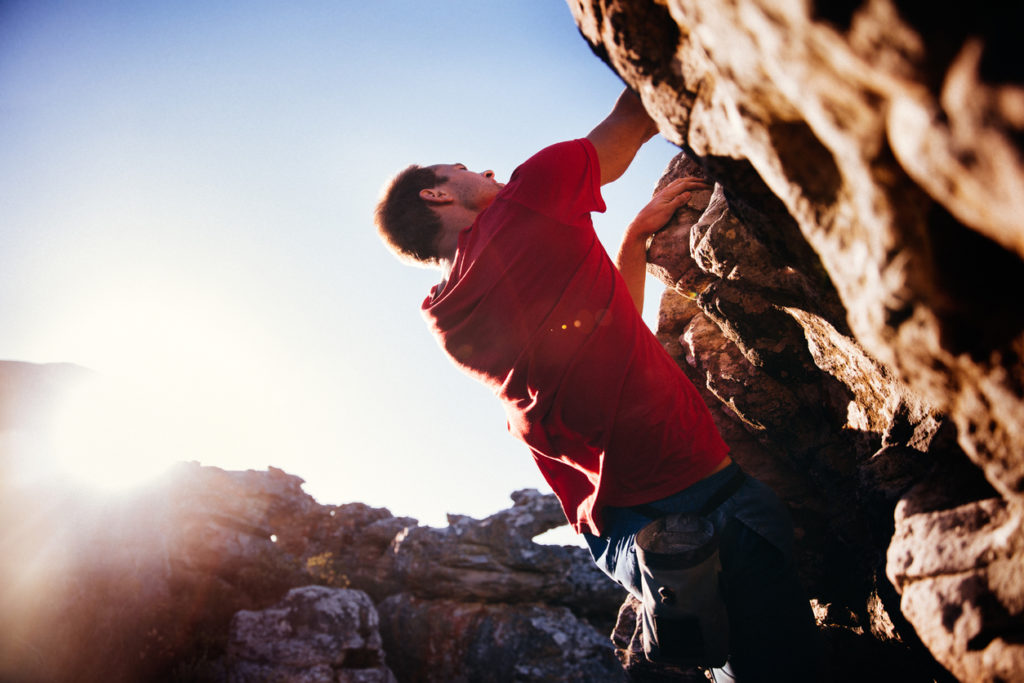 Low angle of extreme free climbing man hanging on rock