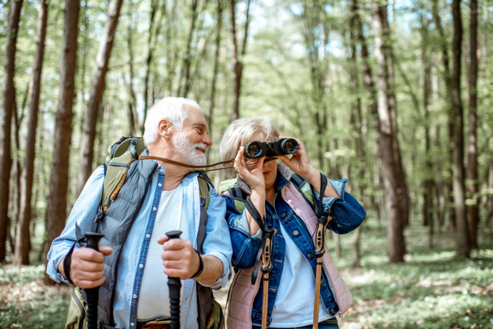 Senior couple bird watching on a hike