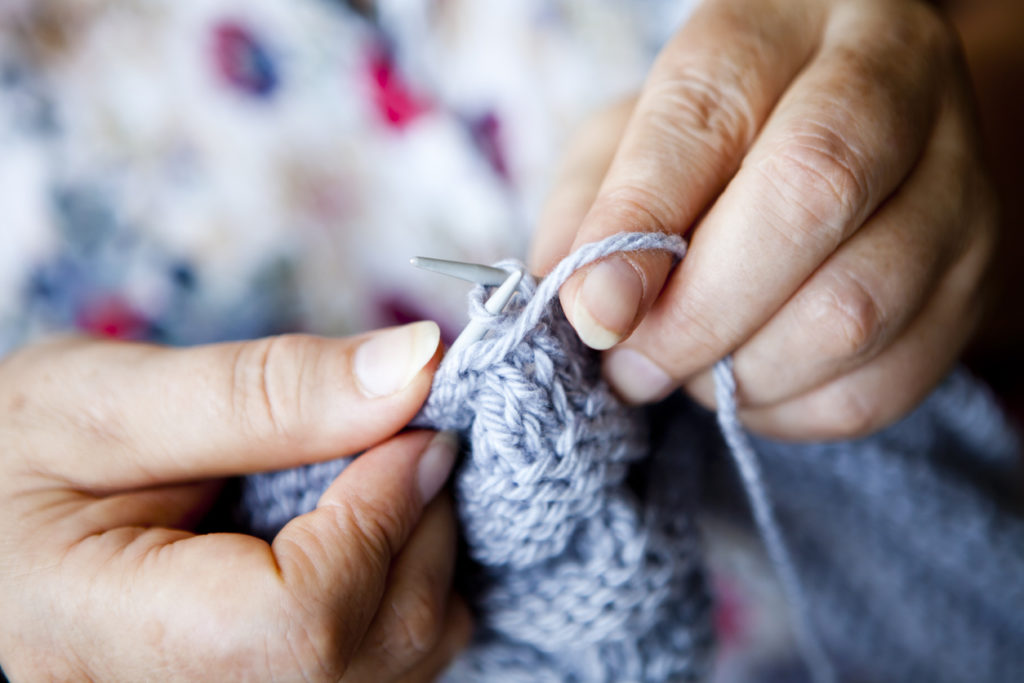 Close-up view of woman hands knitting.