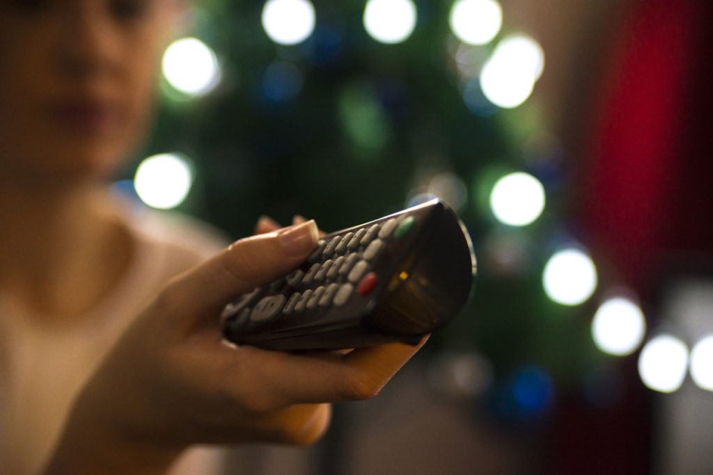 Christmas TV, woman aiming remote control