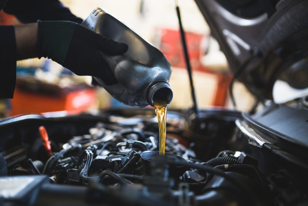 Close up hands of unrecognizable mechanic doing car service and maintenance.