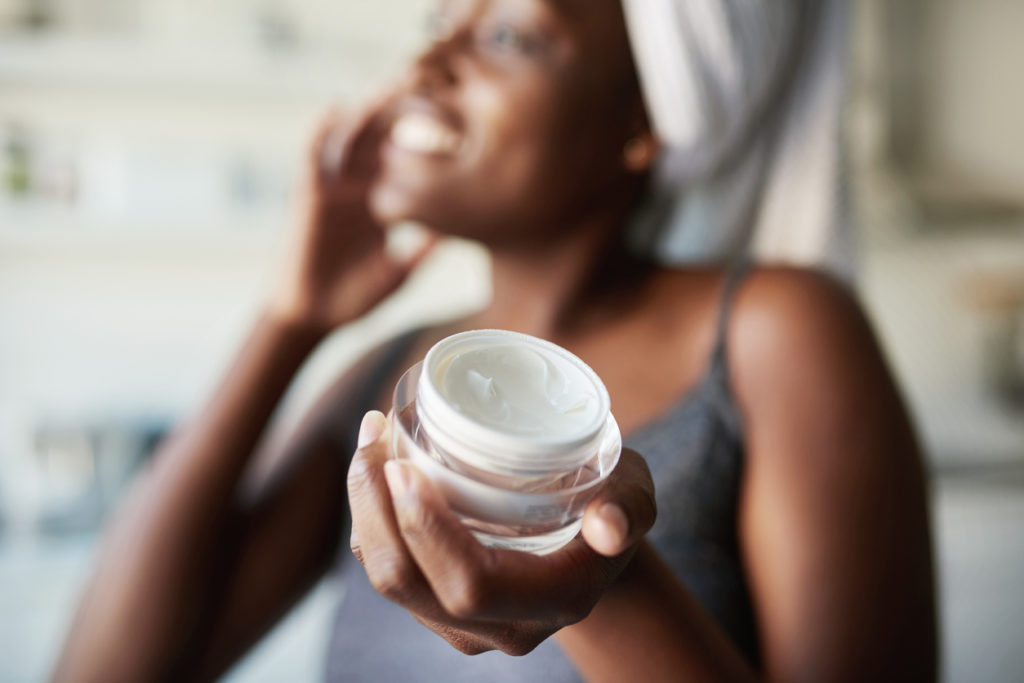 Photo of woman applying moisturizer to her face.