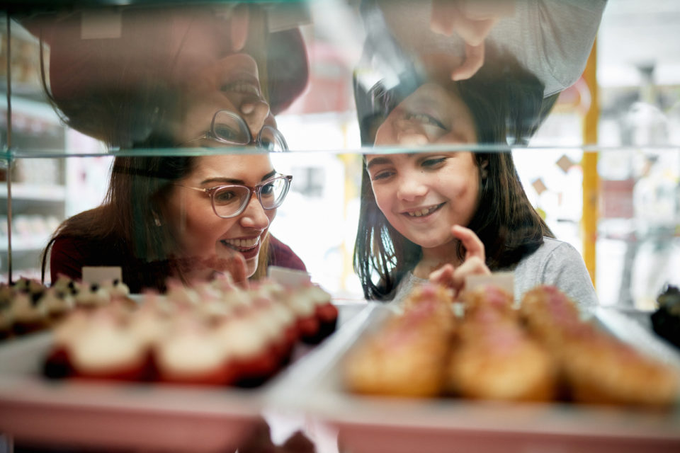 Mother and Daughter Selecting Cupcakes from Display Case