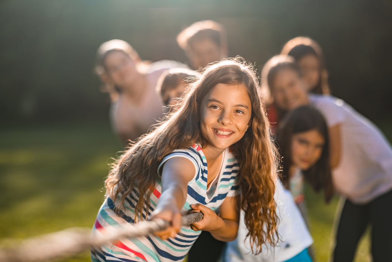 Group of children pulling a rope in public park