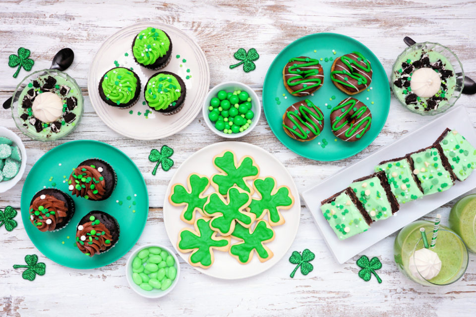 St Patricks Day dessert table scene over white wood